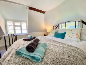 a bedroom with a bed with towels on it at Mortimer Cottage in Wootton Rivers
