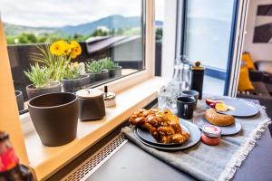 una mesa con platos de comida en el alféizar de la ventana en Apartment,private parking, balcony, smart check in, en Banská Bystrica