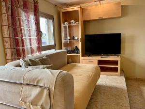 a living room with a couch and a flat screen tv at Las Nasas, Acogedor apartamento cerca de la playa in Arinaga