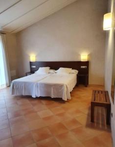 Un dormitorio con una gran cama blanca y una mesa en Hotel Rural Casa Pernías, en Moratalla