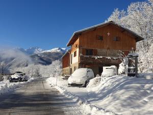 a snow covered house with cars parked in the snow at Chambre d'hôtes à la Chèvrerie de Saint Michel in Beaune