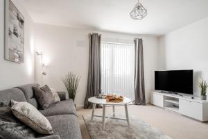 ein Wohnzimmer mit einem Sofa und einem Tisch in der Unterkunft Lovely Modern 2 Bed City Centre Apartment with FREE parking - Double or Twin Beds Available in Wolverhampton