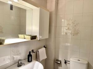 a bathroom with a sink and a toilet and a mirror at Agradable apartamento céntrico en Cangas in Cangas de Morrazo