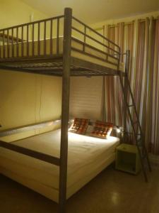 Centre Cauterets, appartement 72m2 pr 7 personnes في كوتيريه: غرفة نوم مع سرير بطابقين مع ملاءات بيضاء