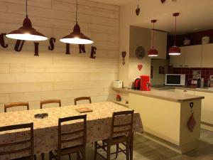 Centre Cauterets, appartement 72m2 pr 7 personnes في كوتيريه: مطبخ مع طاولة وكراسي وأضواء