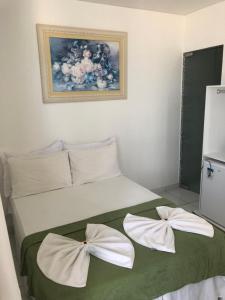 1 dormitorio con 1 cama con 2 almohadas blancas en Pousada Vela Mar, en Maragogi