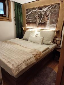 sypialnia z łóżkiem ze zdjęciem jelenia w obiekcie Entspannung pur mit DaheimGefühl w mieście Baiersbronn