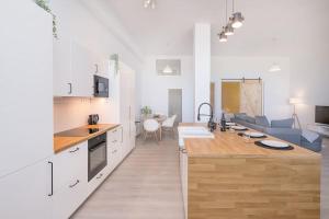 cocina con armarios blancos y sala de estar. en Homey apt Cómpeta en Cómpeta