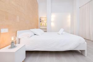 a white bedroom with a white bed and a window at Homey apt Cómpeta in Cómpeta