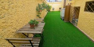 a patio with two benches and a green floor at La A&B Bella vista in Los Prados
