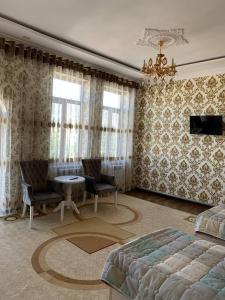 1 dormitorio con 1 cama, mesa y sillas en TURKISTAN Hotel en Kogon