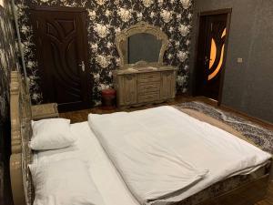 Dormitorio con cama con espejo y tocador en TURKISTAN Hotel en Kogon