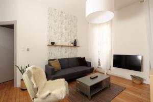 a living room with a couch and a tv at Confortable T2 à Saint Aubin in Toulouse