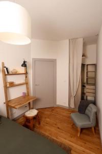 uma sala de estar com uma cadeira e uma mesa em Confortable T2 à Saint Aubin em Toulouse