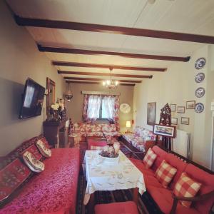 a living room with red couches and a table at Country House in Ktistádes