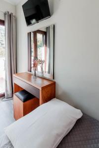 1 dormitorio con escritorio de madera y espejo en Grigoris Garden, en Parga