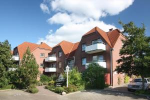 un grupo de casas con coches estacionados en un estacionamiento en Apartmenthaus Holländerei, en Büsum