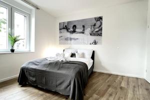 1 dormitorio con 1 cama en una habitación blanca en Favorite Stays - Suite And More - 10 Min zur Messe, en Düsseldorf