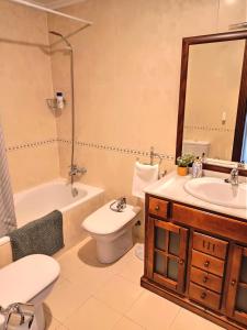 a bathroom with a sink and a toilet and a tub at LA ERIA I, muy soleado, Wifi, garaje, 15 min a pie al centro in Oviedo