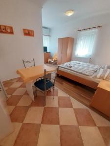 1 dormitorio con 1 cama, mesa y sillas en Petra Apartmanház, en Kehidakustány