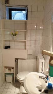 ein weißes Bad mit einem WC und einem Waschbecken in der Unterkunft Ferienzimmer am See in Ratzeburg