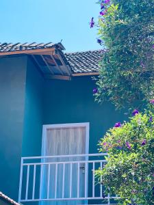 una casa azul con un balcón blanco y flores en WildZone, en Anachal