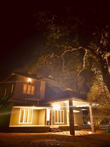 una casa iluminada por la noche con luces en WildZone, en Anachal