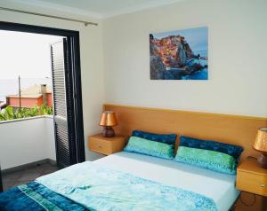 una camera da letto con un letto e una grande finestra di Casa MaBu by Your Madeira Rentals a Paul do Mar Altre 32 foto