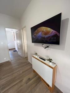 een woonkamer met een flatscreen-tv aan de muur bij Appartement rénové à 15 min de Lyon in Saint-Fons