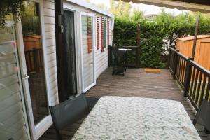 a porch with a table and chairs on a house at Mobil-Home 3 chambres à "Les Mathes" in Les Mathes