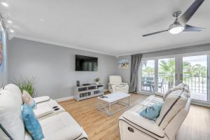 a living room with two white couches and a tv at Holiday Villas 2 104 in Clearwater Beach
