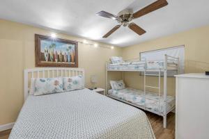 a bedroom with a bunk bed and a ceiling fan at Holiday Villas 2 104 in Clearwater Beach +36 photos