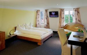 a bedroom with a bed with white pillows on it at Gasthof Löwen in Bubikon