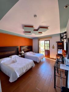 Habitación de hotel con 2 camas y ventana en Hotel Hacienda Real en Querétaro