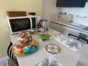 uma mesa de cozinha com um micro-ondas e um prato de comida em Frida em San Giorgio a Cremano