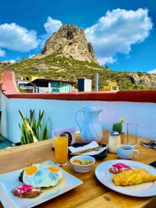 una mesa con desayuno y una montaña en el fondo en Hotel Hacienda Real en Querétaro