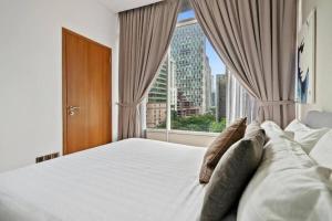 a bedroom with a large bed with a large window at Vortex Suites KLCC in Kuala Lumpur