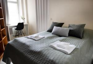 1 dormitorio con 1 cama con 2 toallas en 2ndhomes City Center 2BR Apartment with Balcony and Sauna by Kaisaniemi Park, en Helsinki