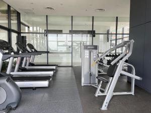 ein Fitnessstudio mit Laufbändern und Geräten in einem Raum in der Unterkunft The Aspen, 3BR Cityview by WStay @Tropicana 218 Macalister in George Town
