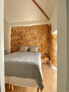 1 dormitorio con 1 cama con pared de ladrillo en LIMA Gorgeous Loft at Arrábida, en Azeitão