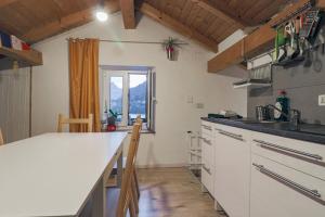 uma cozinha com um balcão branco e uma janela em Una Civetta sul Lago em Alleghe
