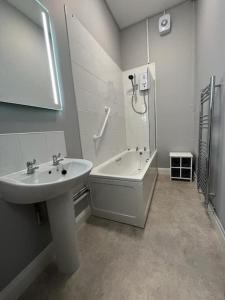 a bathroom with a sink and a shower and a bath tub at 3 Bedroom Self Contained Ground Floor Flat With Parking in Plymouth