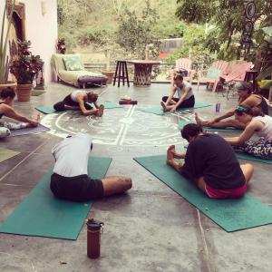 eine Gruppe von Menschen, die auf Matten sitzen und auf den Boden malen in der Unterkunft My Sisters House - Female only in Sayulita