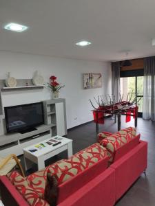 sala de estar con 2 sofás rojos y TV en PISO NUEVO EN MOAÑA en Moaña