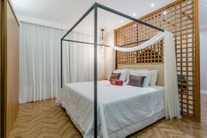 a bedroom with a white bed with a canopy at Victory Business Hotel in Juiz de Fora