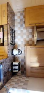 cocina con armarios de madera y suelo de baldosa en The TJ Rooms en Upton