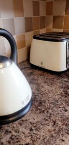 a white toaster sitting on a counter next to a toaster at The TJ Rooms in Upton