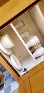 a kitchen with white plates in a drawer at The TJ Rooms in Upton
