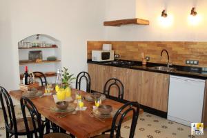 cocina con mesa de madera con sillas y fregadero en Cortijo Huerta Galindo, en Alanís