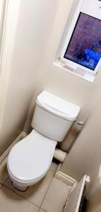 a bathroom with a toilet and a window at The TJ Rooms in Upton